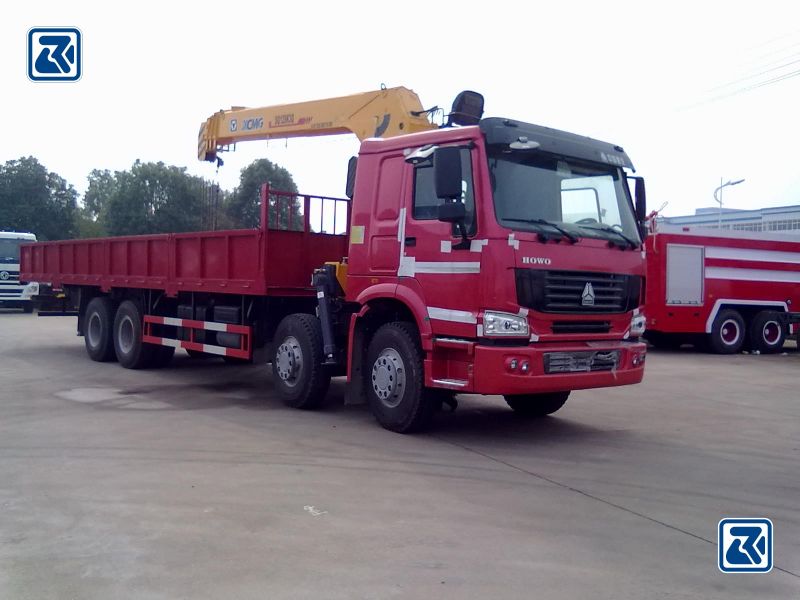 Vue latérale de la grue sur camion HOWO 8X4 avec la grue jaune entièrement déployée