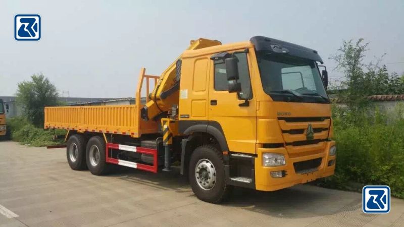 Vue latérale d'un camion-grue Howo 6x4 robuste, mettant en évidence son espace de chargement spacieux et sa technologie de grue avancée.