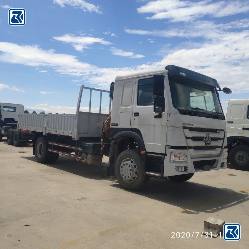 Vue latérale d'une grue sur camion HOWO 4x2, avec sa conception efficace pour le transport et les travaux de grutage lourds.